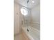 Bright bathroom features a glass-enclosed tub, shower, and a unique round window at 1101 Juniper Ne St # 632, Atlanta, GA 30309
