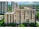 A mid-rise condominium building featuring a tan facade, balconies, and surrounding greenery in a vibrant urban setting at 1101 Juniper Ne St # 632, Atlanta, GA 30309