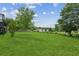 Large backyard area featuring green grass with surrounding trees and a deck at 2055 Cactus Ln, Cumming, GA 30040