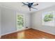 Bedroom with hardwood flooring, two windows, and a whimsical airplane-themed ceiling fan at 2055 Cactus Ln, Cumming, GA 30040
