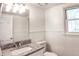 Neat bathroom with wainscoting, a granite countertop vanity, and a framed mirror above the sink at 2745 Saxon Drive, Duluth, GA 30096