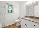 Bright bathroom features a window and a vanity with a granite counter and marble-look tiled walls at 2745 Saxon Drive, Duluth, GA 30096