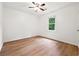 Well-lit bedroom with ceiling fan, wood-look flooring, and a window view at 2745 Saxon Drive, Duluth, GA 30096
