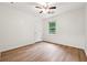 A bedroom with wood-look floors, a window, ceiling fan, and a door at 2745 Saxon Drive, Duluth, GA 30096