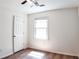 Bright bedroom with hardwood floors, ceiling fan, window, and white door at 2745 Saxon Drive, Duluth, GA 30096