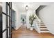 Bright entryway with hardwood floors, staircase, modern light fixture, and decorative tree at 2745 Saxon Drive, Duluth, GA 30096