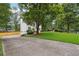Front exterior featuring a long driveway, luscious green lawn, and mature trees at 2745 Saxon Drive, Duluth, GA 30096