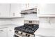 Stainless steel stove and range hood with white subway tile backsplash and quartz countertops at 2745 Saxon Drive, Duluth, GA 30096