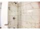 Modern shower featuring bright white marble-patterned tiling and chrome fixtures at 2745 Saxon Drive, Duluth, GA 30096