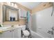 Bright bathroom featuring a shower-tub combo, white vanity and cabinet, and a decorative mirror at 4715 Northridge Dr, Cumming, GA 30040