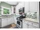 Well-equipped kitchen with stainless steel appliances, mosaic backsplash, and bright natural light at 4715 Northridge Dr, Cumming, GA 30040