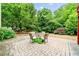 Charming patio with stone pavers, outdoor seating, and a lush, private backyard area surrounded by mature trees at 4715 Northridge Dr, Cumming, GA 30040