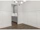 Dining area with hardwood flooring, white walls with wainscoting and adjacent kitchen with gray cabinets at 7169 Linden Dr, South Fulton, GA 30349