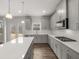 Modern kitchen with gray cabinets, white countertops, stainless steel appliances, and an island with pendant lights at 7169 Linden Dr, South Fulton, GA 30349