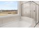 Bright bathroom showcasing a tub, tiled shower, and a view of the yard at 7171 Linden Dr, South Fulton, GA 30349