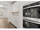 Close-up of the double oven and kitchen cabinets with stylish backsplash and hardwood floors at 7171 Linden Dr, South Fulton, GA 30349