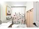 A bathroom with a floral shower curtain, modern fixtures, and attractive wall art at 3320 Goldmist Dr, Buford, GA 30519