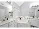 Bright bathroom featuring a soaking tub, double vanity, and tiled backsplash for a clean, fresh look at 3320 Goldmist Dr, Buford, GA 30519