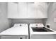 Functional laundry room with white cabinets and modern Samsung washer and dryer units at 3320 Goldmist Dr, Buford, GA 30519