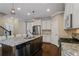 Modern kitchen with white cabinetry, stainless appliances, large island and hardwood flooring at 3920 Baverton Dr, Suwanee, GA 30024