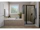 Bright main bathroom featuring a luxurious bathtub, separate shower with tiled surround at 3920 Baverton Dr, Suwanee, GA 30024