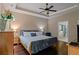 Cozy main bedroom featuring wood floors, ample natural light, and a glimpse into the attached bathroom at 3920 Baverton Dr, Suwanee, GA 30024