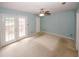 Bedroom with ceiling fan, carpet flooring, double doors and private balcony access at 5461 Park S Pl, Atlanta, GA 30349