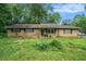 Ranch-style home featuring a brick exterior, surrounded by trees, and a spacious front yard at 2087 Chestnut Way, Lithia Springs, GA 30122