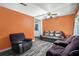 Living room featuring hardwood floors, bright orange walls, and a ceiling fan at 2087 Chestnut Way, Lithia Springs, GA 30122