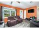 Living room with hardwood floors, tv, orange walls, and natural light at 2087 Chestnut Way, Lithia Springs, GA 30122