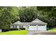 Single story home with a two-car garage, black shutters and green lawn at 225 Magnolia Tree Ct, Johns Creek, GA 30022