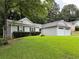 Single story home with two-car garage and lawn at 225 Magnolia Tree Ct, Johns Creek, GA 30022
