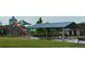 Community playground featuring colorful slides, climbing structures, covered picnic tables, and green space at 225 Magnolia Tree Ct, Johns Creek, GA 30022
