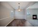 Dining room showcases hardwood floors, a modern chandelier, and a cozy fireplace nearby at 3223 Tallon Sw Ln, Atlanta, GA 30311