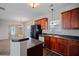 Open kitchen with a large island, cherry cabinets, and black appliances overlooking dining area at 3223 Tallon Sw Ln, Atlanta, GA 30311