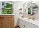 Bathroom featuring a white vanity, round mirror and decorative shelving at 3362 Northbrook Dr, Atlanta, GA 30340