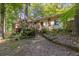 View of the back exterior featuring brick, stairs, and decks surrounded by beautiful trees and nature at 3362 Northbrook Dr, Atlanta, GA 30340