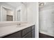 Bathroom with neutral vanity, framed mirror, and walk-in shower with tiled walls and floors at 5555 Mountain Springs Cir, Stone Mountain, GA 30088