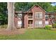 Inviting two-story home with a brown exterior, balcony, and a well-maintained lawn with mature trees at 5555 Mountain Springs Cir, Stone Mountain, GA 30088