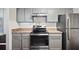 Cozy kitchen with gray cabinets, stainless steel appliances, tile backsplash, and dark countertops at 5555 Mountain Springs Cir, Stone Mountain, GA 30088