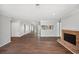 Open-concept living area with a brick fireplace, hardwood floors, and a view into the kitchen at 5555 Mountain Springs Cir, Stone Mountain, GA 30088