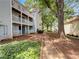 Back of multi-story condo with private balconies, lush landscaping and walkway at 219 Cobblestone Trl, Avondale Estates, GA 30002