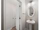 Elegant half-bath featuring a pedestal sink, decorative mirror, and modern fixtures at 3610 Silvery Way, Powder Springs, GA 30127