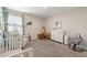 Cozy Bedroom with a crib, rocking chair, and changing table at 3610 Silvery Way, Powder Springs, GA 30127