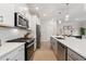 Modern kitchen featuring stainless appliances, white cabinetry, quartz counters, and stylish pendant lighting at 3610 Silvery Way, Powder Springs, GA 30127