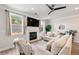 Cozy living room with a fireplace, large windows, plush seating, and a ceiling fan at 3610 Silvery Way, Powder Springs, GA 30127