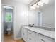 Bathroom with granite vanity, updated lighting, and an adjacent toilet area with natural light at 4168 Arapaho Dr, Powder Springs, GA 30127