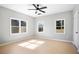 Bright bedroom featuring a ceiling fan, three windows and light, neutral paint at 4168 Arapaho Dr, Powder Springs, GA 30127