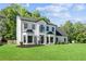 Two story white and black home featuring a lush lawn and mature trees at 4168 Arapaho Dr, Powder Springs, GA 30127
