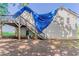 Angled view of home with deck and stairs, with a blue tarp covering the roof at 42 Breckenridge Dr, Powder Springs, GA 30127